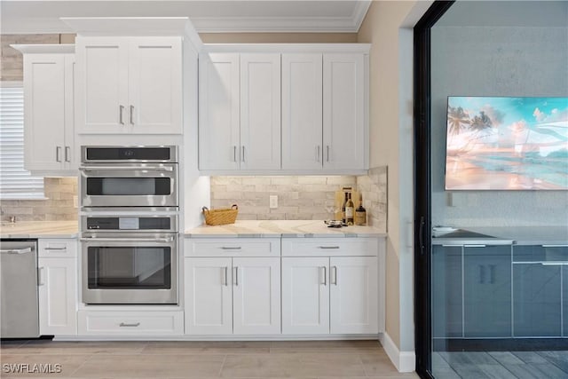 kitchen with backsplash, white cabinetry, and stainless steel appliances