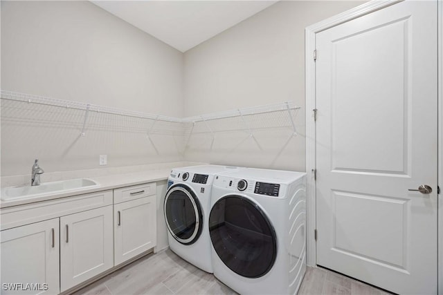 laundry area with sink, cabinets, and independent washer and dryer