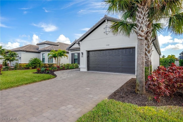 mediterranean / spanish-style home featuring a garage and a front lawn