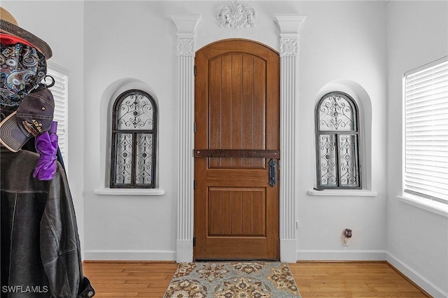 entrance foyer with decorative columns and light wood-type flooring