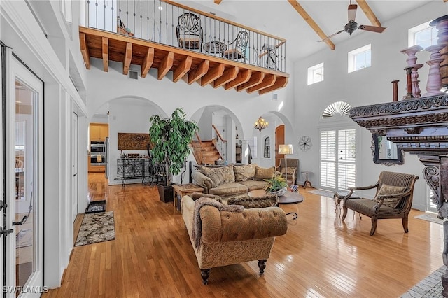 living room featuring plenty of natural light, wood-type flooring, and a high ceiling