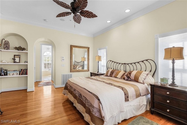 bedroom with light hardwood / wood-style floors, ceiling fan, and crown molding