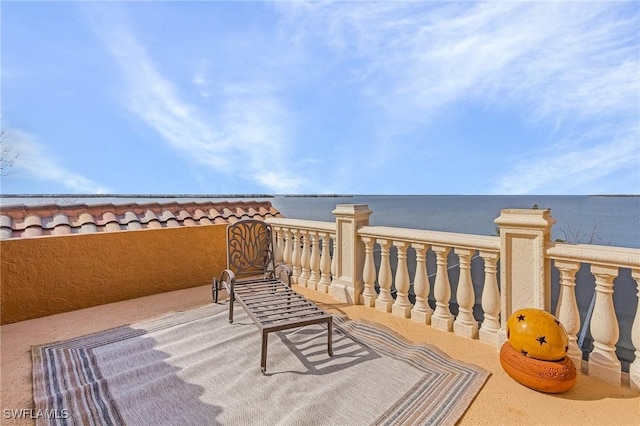 view of patio with a water view and a balcony