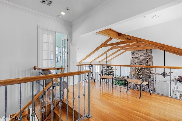 living area featuring hardwood / wood-style floors, vaulted ceiling, and ornamental molding