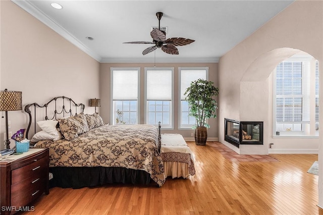 bedroom with ceiling fan, light wood-type flooring, and crown molding