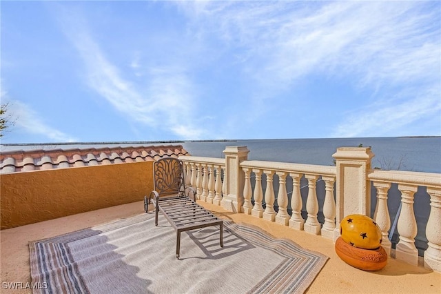 view of patio featuring a water view and a balcony