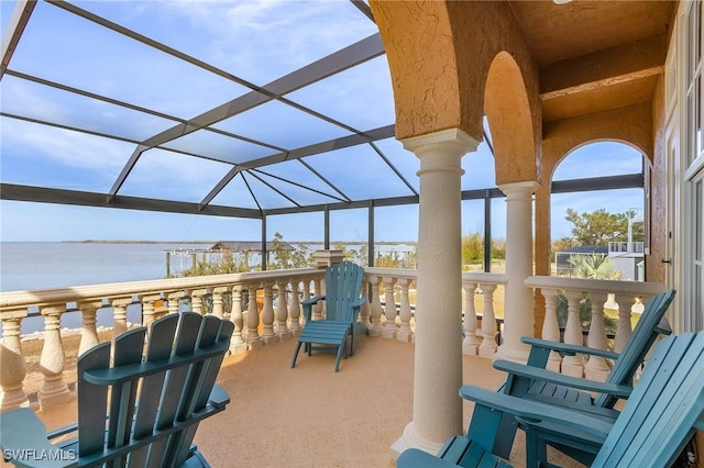 view of patio / terrace featuring glass enclosure and a water view