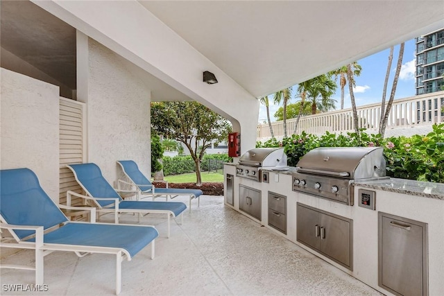 view of patio with exterior kitchen and a grill