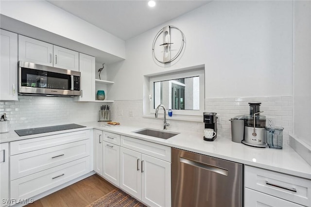 kitchen featuring sink, decorative backsplash, appliances with stainless steel finishes, dark hardwood / wood-style flooring, and white cabinetry