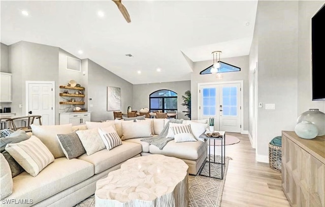 living room featuring french doors, light wood-type flooring, ceiling fan, and lofted ceiling