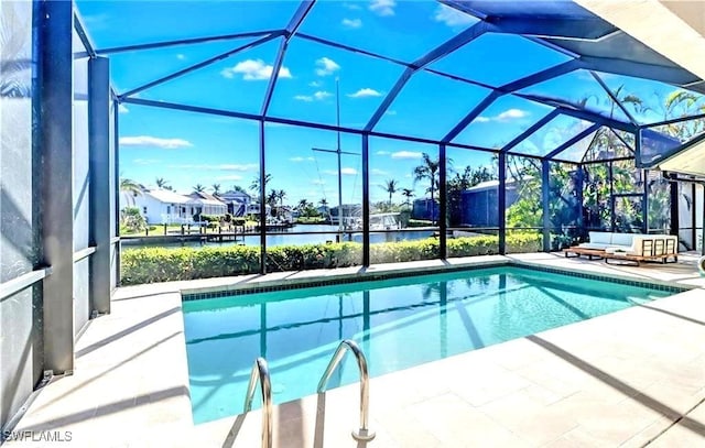 view of pool featuring glass enclosure, a water view, and a patio