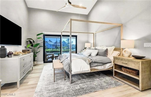 bedroom featuring access to exterior, high vaulted ceiling, light wood-style floors, and a ceiling fan