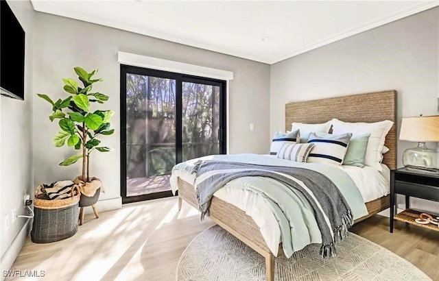 bedroom with light wood finished floors, access to exterior, and ornamental molding