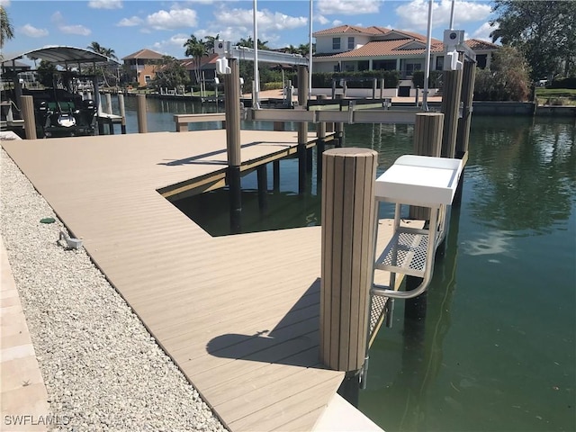 dock area with a water view and boat lift