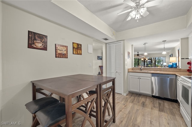 dining area with light wood-type flooring, ceiling fan, and sink