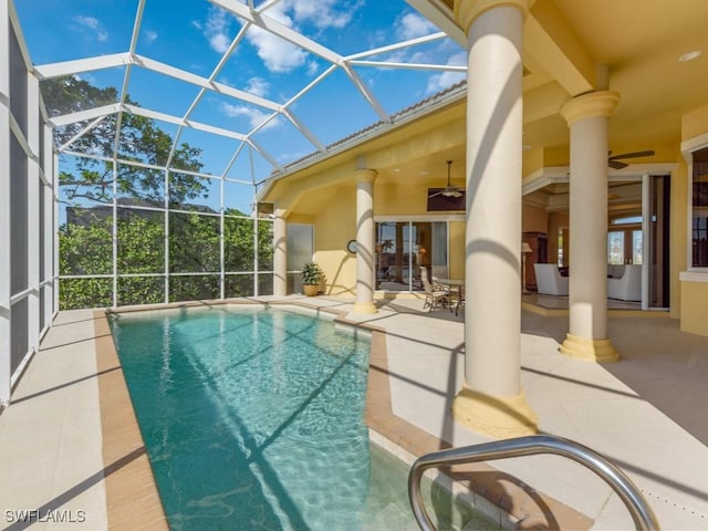 view of pool featuring ceiling fan, a patio, and glass enclosure