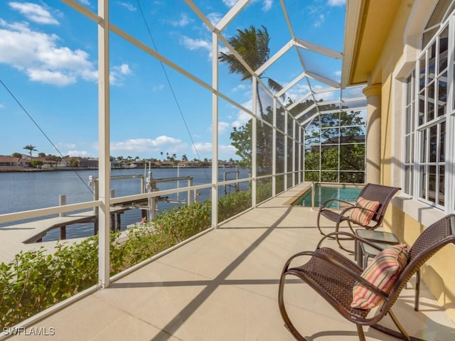 unfurnished sunroom with a water view and a pool