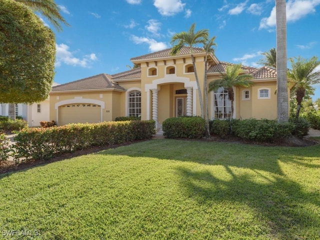 mediterranean / spanish house with a front yard and a garage