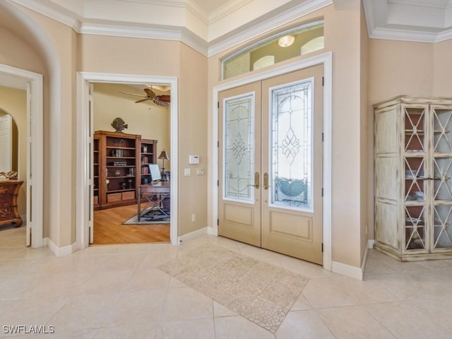 entrance foyer with ceiling fan, light tile patterned flooring, ornamental molding, and french doors