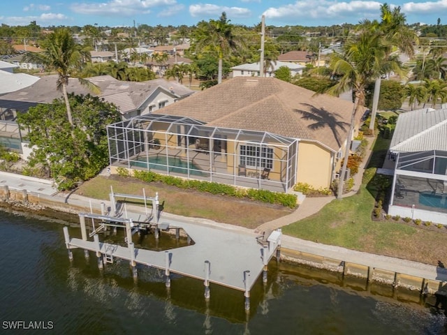 rear view of house featuring a lanai and a water view