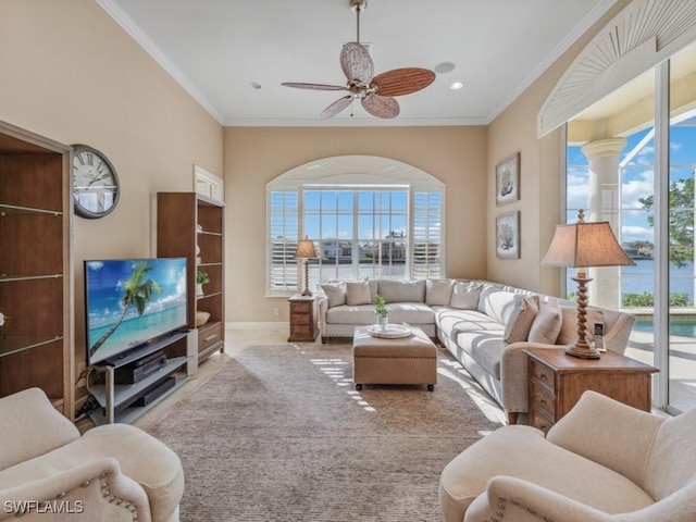 living room featuring ceiling fan, crown molding, and a wealth of natural light