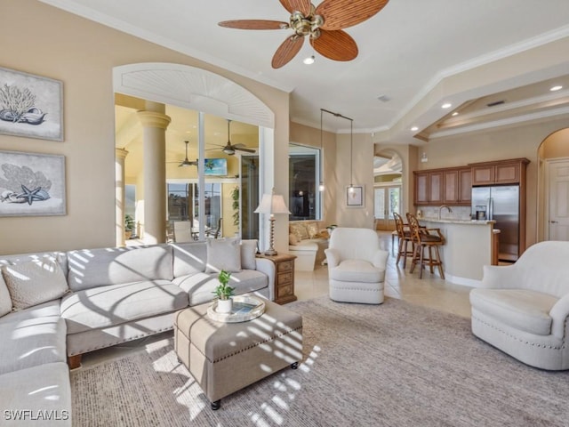 tiled living room featuring ceiling fan, sink, and crown molding