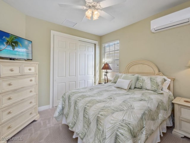 bedroom featuring ceiling fan, an AC wall unit, light carpet, and a closet