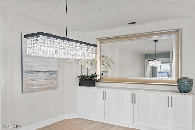 bathroom featuring wood-type flooring and a chandelier