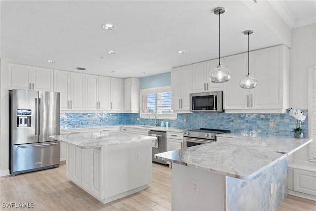 kitchen with light stone countertops, white cabinets, stainless steel appliances, and a kitchen island