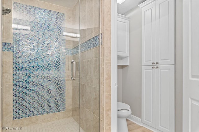 bathroom featuring hardwood / wood-style floors, an enclosed shower, and toilet