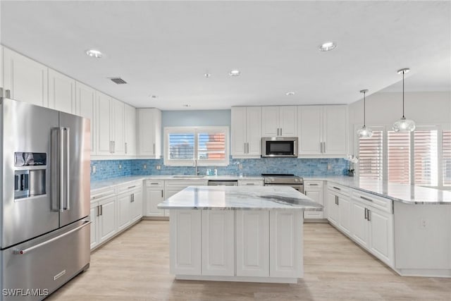 kitchen with a center island, white cabinetry, and appliances with stainless steel finishes