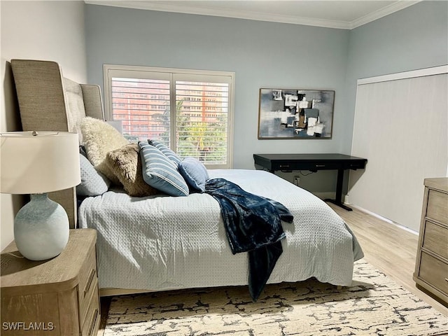 bedroom with crown molding and light hardwood / wood-style flooring