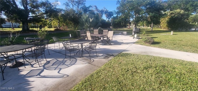 view of property's community with a patio area and a lawn