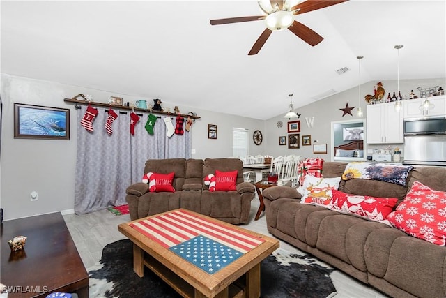 living room with ceiling fan, lofted ceiling, and light wood-type flooring