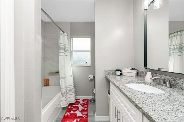 bathroom with wood-type flooring, vanity, and shower / bath combo