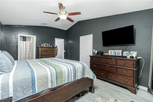 bedroom featuring light wood-type flooring, vaulted ceiling, and ceiling fan