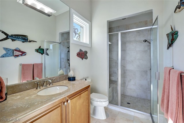 bathroom with tile patterned flooring, vanity, toilet, and a shower with shower door