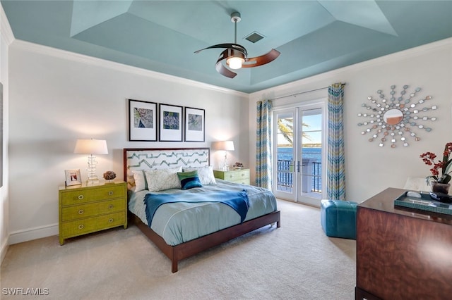 carpeted bedroom featuring access to outside, crown molding, ceiling fan, and a tray ceiling