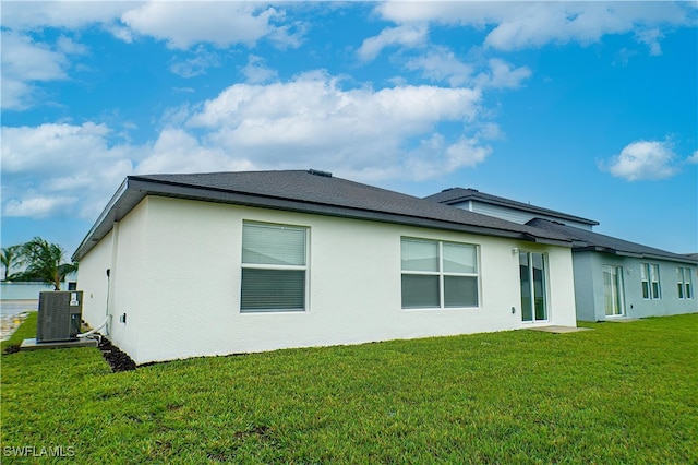 rear view of house with a yard and central AC unit