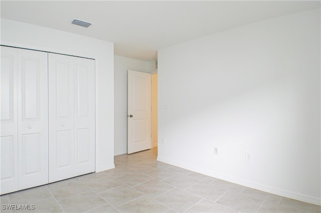 unfurnished bedroom featuring a closet and light tile patterned flooring