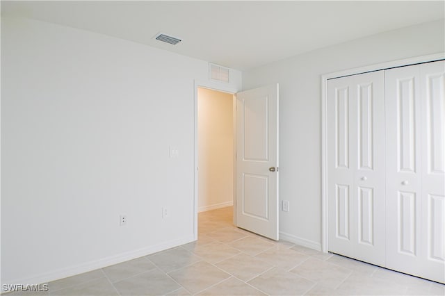 unfurnished bedroom featuring light tile patterned floors and a closet