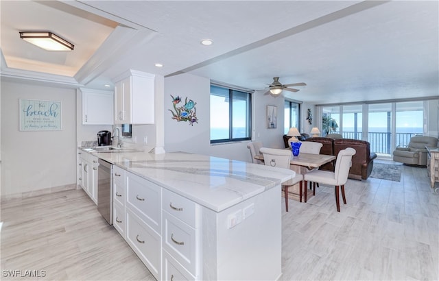 kitchen featuring white cabinetry, sink, ceiling fan, light stone counters, and kitchen peninsula