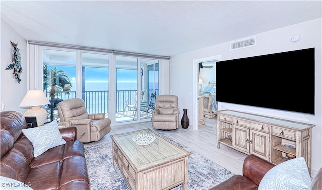 living room with light wood-type flooring and ceiling fan