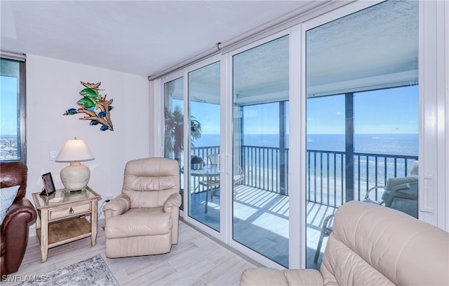 living room featuring expansive windows, a healthy amount of sunlight, and a water view