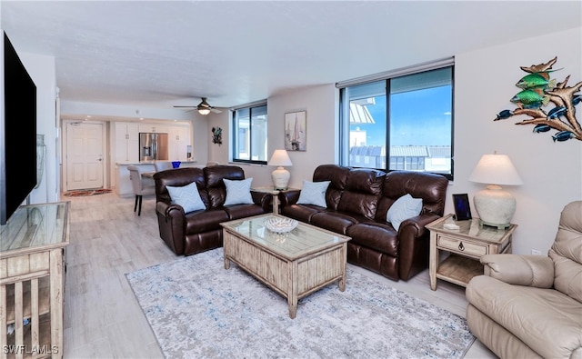 living room featuring ceiling fan and light hardwood / wood-style floors