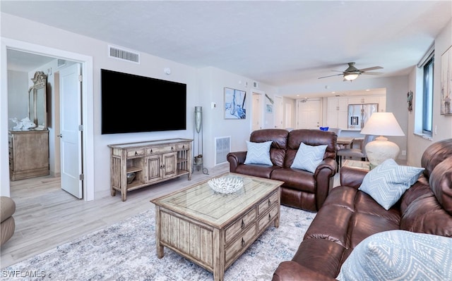 living room with light hardwood / wood-style flooring and ceiling fan