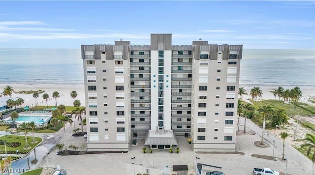 view of building exterior with a water view and a view of the beach