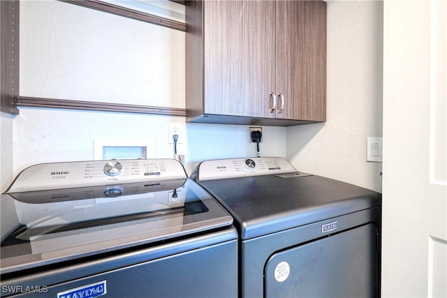 washroom with cabinets and washing machine and clothes dryer