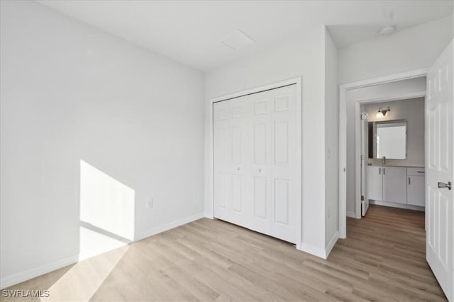 unfurnished bedroom with light wood-type flooring and a closet