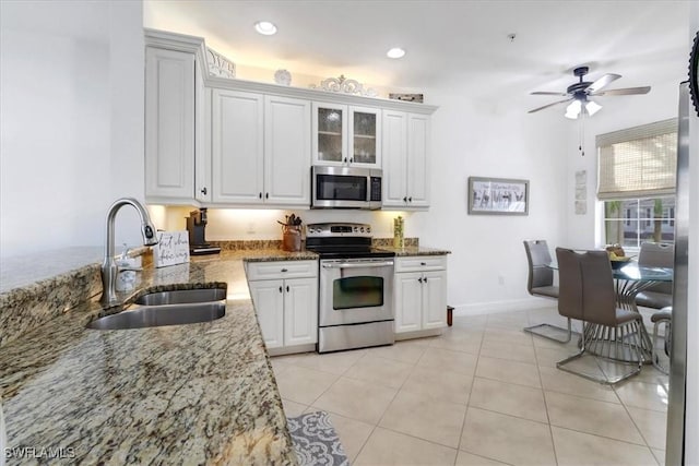 kitchen featuring stone counters, sink, white cabinets, and stainless steel appliances